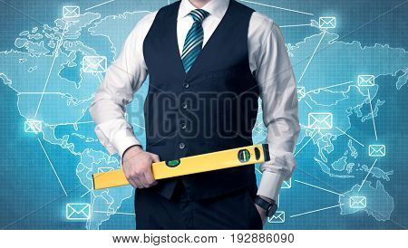 Businessman holding tool with global map graphic on the background