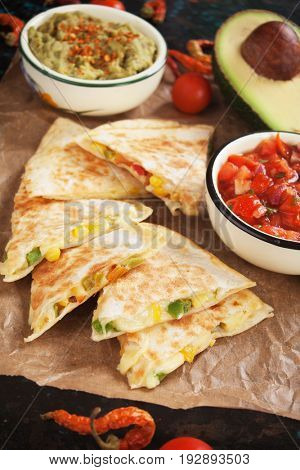 Mexican quesadillas, cheese filled tortila wraps with salsa and guacamole