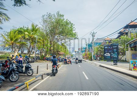 BALI- INDONESIA MARCH 08. 2017: Unidentified motorcyclist rides down the street. Legian's area. Legian is a suburban and beach area on the west coast of Bali.