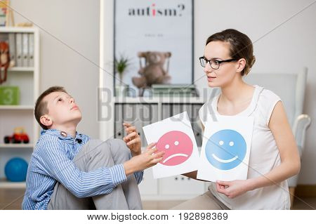 Professional psychologist working with autistic boy in her office