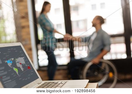 Young expert. Two successful professional people shaking hands with his colleague while asking her joining his team on his new startup