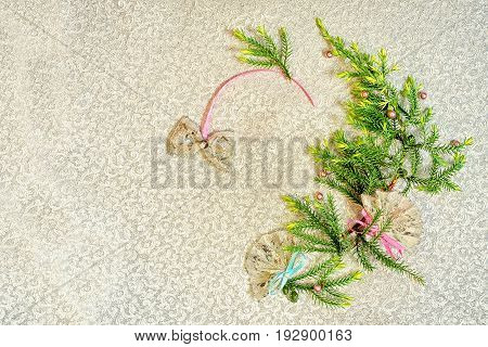 Christmas tree wreath silhouette made from fir branches on a gold cloth background with copy space for your text.