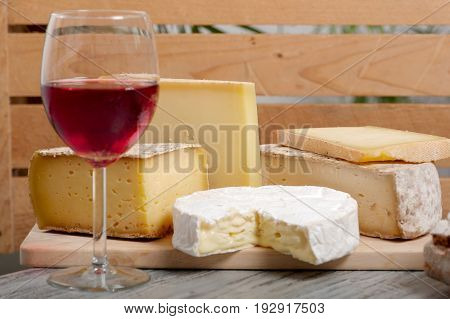 Different french cheeses with a glass of red wine