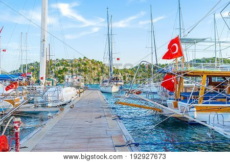 KEKOVA TURKEY - MAY 7 2017: The walk along the pier of port between tourist yachts on May 7 in Kekova