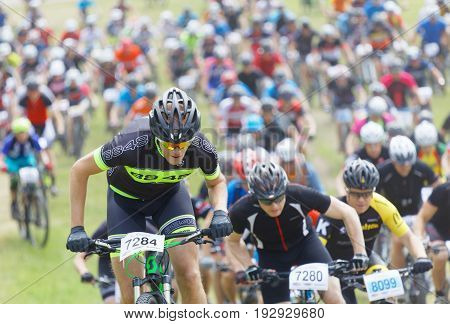 STOCKHOLM SWEDEN - JUNE 11 2017: Lots of mountain bike cyclist struggling in a steep uphill at Lida Loop Mountain bike Race. June 11 2017 in Stockholm Sweden