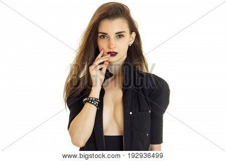 Portrait of an attractive brunette who poses in the Studio with unfastened black jacket and dark lipstick on your lips is isolated on a white background.