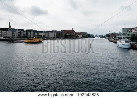 Copenhagen Denmark - August 12 2016: Waterfront of Copenhagen with nautical vessel on the water a cloudy summer day