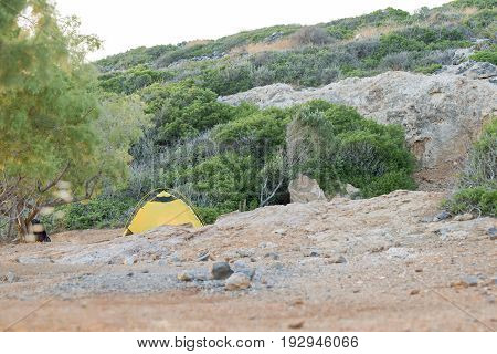 Camping in the mountains, lonely yellow tent in Kolokitha Island, Crete, Greece