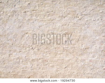 Steinmauer, die teilweise mit Gips überzogen
