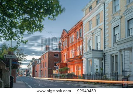 Southgate Street in central Winchester on a warm summer's evening at dusk. Cars are passing and captured as light trails.