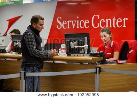 VIENNA/ AUSTRIA - APRIL 6, 2017. Service center at the Vienna airport Schwechat, Austria. An employee helps a passenger to obtain the necessary information.