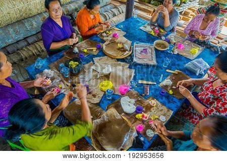 BALI, INDONESIA - MARCH 08, 2017: Women preparing an Indian Sadhu dough for chapati on Manmandir ghat on the banks of the holy river Ganges in Varanasi.