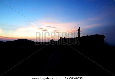 A Woman Stands At The Top Of A Volcano Watching The Sunrise
