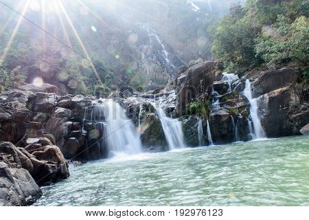 Lodh waterfall with sun rays in Jharkhand,India. Lens flare and light leak.