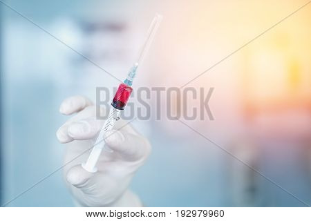 nurse holds a syringe with a universal vaccine against the zik virus, epidemic of ebola, poultry and swine flu, malaria, hepatitis. The concept of saving from disease.