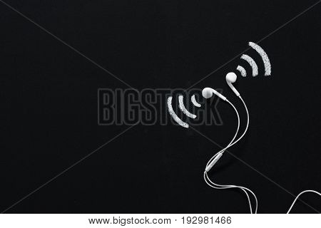 Modern Earphones With Sound Sign Drawn On Black Chalkboard