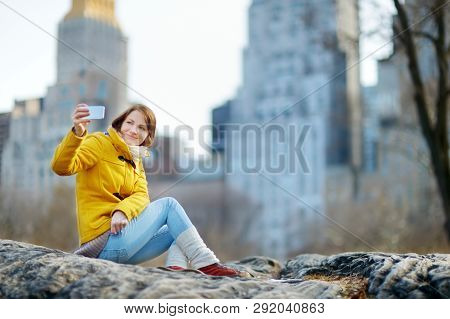 Happy Young Woman Tourist Taking Pictures At Central Park In New York City. Female Traveler Enjoying
