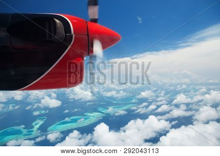 Tropical islands, view from hydroplane. Clouds in the blue sky, flight under islands in the ocean