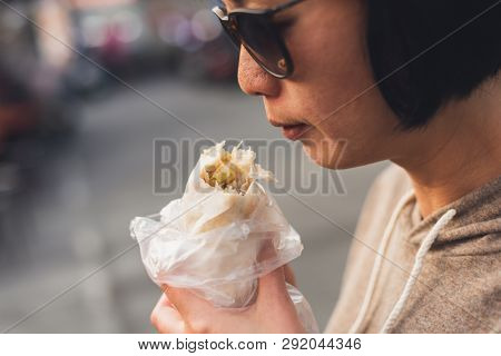 woman eat traditional Taiwanese snack of spring roll
