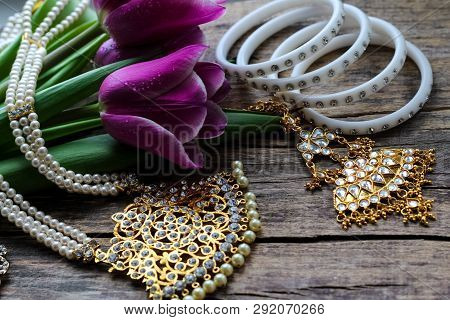 Indian Decorations For Dancing: Bracelets, Necklace. Purple Ultraviolet Tulips On Old Rustic Wooden