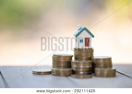 Mini House On Stack Of Coins,money And House,  Mortgage, Savings Money For Buy House And Loan To Bus