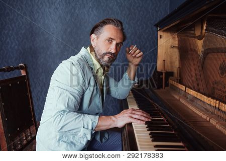 Composer Composes Music At The Piano. A Beard And A Cigarette In His Hand Gives Him Brutality.