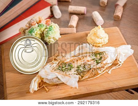 Spicy Sea Bass With Cooked Vegetables And Mashed Potatoes Served In A Cook Paper On A Wooden Board.