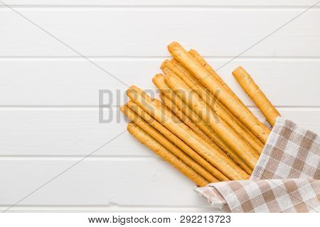 Italian grissini breadsticks. Tasty grissini snack on white table. Top view.