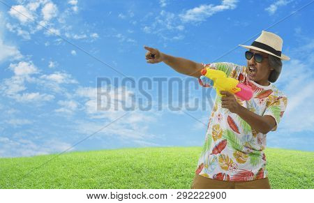 Happy Elderly Traveler Asian Man Wearing Summer Shirt, Straw Hat And Sunglasses Holding Colorful Wat
