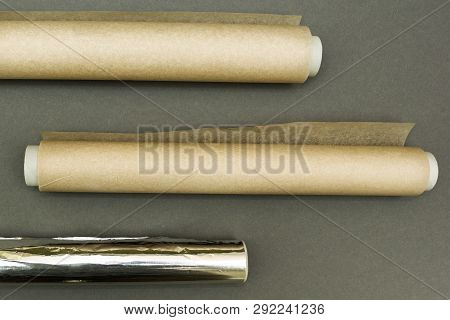 Plastic Wraps And Roll Of Aluminum Foil On Grey Background.
