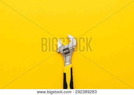 Adjustable Wrench With Yellow Handle. Minimalist Shot Of Yellow Adjustable Wrench. Top View Of The A