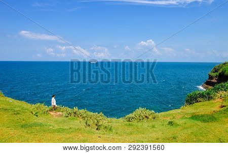 Single Chinese Girl Stands On Field Of Grass, Looking At Ocean, On Weizhou Island At Beihai City, Gu