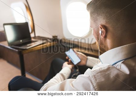 Young Attractive And Successful Businessman Is Resting And Listening To Music Works While Sitting In