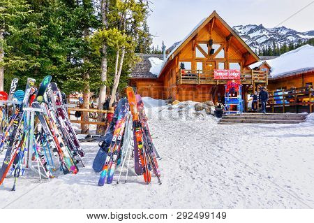 Lake Louise, Canada - Mar 23, 2019: Colorful Skis And Snowboards Line The Rack Outside The Old And R