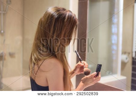 Woman Applaying Make Up . The Beauty Concept