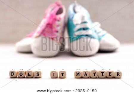 Pink And Blue Baby Booties On A Light Background. Inscription Does It Matter