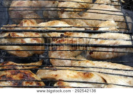 Chicken Wings On Barbecue Grill With Fire Smoking.