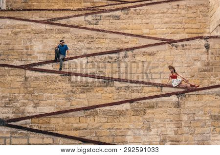 Man And Woman Sitting On The City Walls, Old City Of The Three Cities, Malta