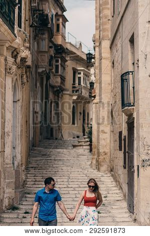 Man And Woman Walking On The Stairs On The Street, Old City Of The Three Cities, Malta