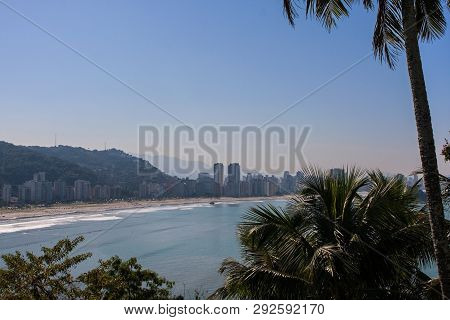 Sao Vicente, Brazil - July 2018:  Elevated Wide Shot View Through Palm Trees Showing Shoreline Of Th