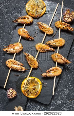 Grilled Shrimp Skewers With Herbs, Garlic And Lemon On Stone Background. Seafood, Shelfish.