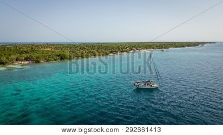 A Sailing Boat Anchored In Blue Water Sea With The Island Islas De San Bernardo Of The Atlantic Coas