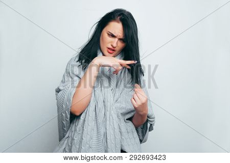 Upset Young Beautiful Girl In A Gray Robe, Folding Her Fingers In The Form Of Scissors Cuts Off A St