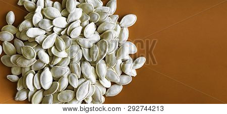 Pumpkin Seeds Or Pepitas Isolated On Orange Background - Raw Pepita Or Pumpkin Seed With Copy Space 