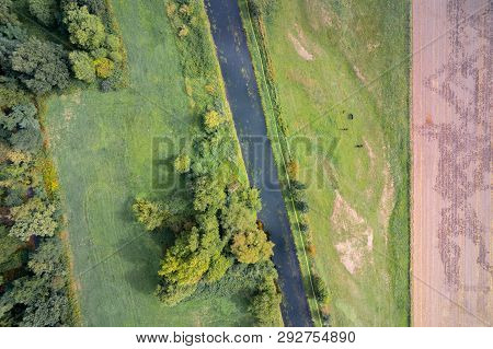 River Niers Besides Forrest And Meadows With Horses At The Niederrhein Region In West Germany