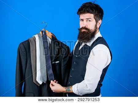 Which Tie Should I Wear. Bearded Man Matching Neck Tie Color To Coat. Brutal Hipster Holding Colorfu