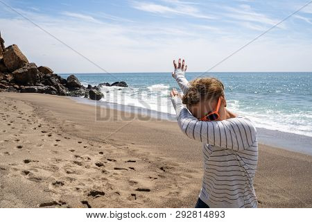 Adult Caucasion Woman Does A Dabbing Dance Move While On The Beach. Taken At Point Dume Malibu Calif