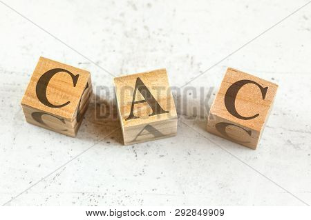 Three Wooden Cubes With Letters Cac Stands For Customer Acquisition Cost On White Board.