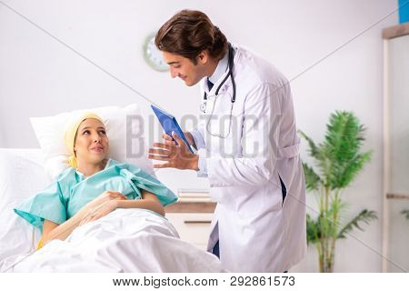 Young handsome doctor visiting female oncology patient 