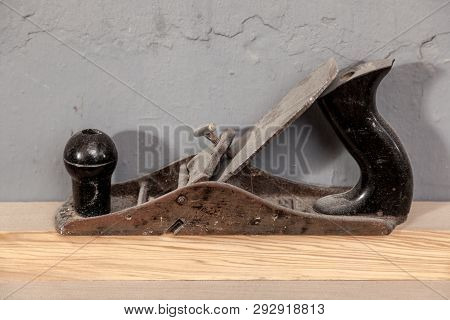 Close-up Black Metal Planer And Plastic For Wood Processing Stands On A Wooden Table Against The Bac